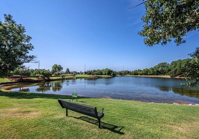 view of home's community with a water view and a yard