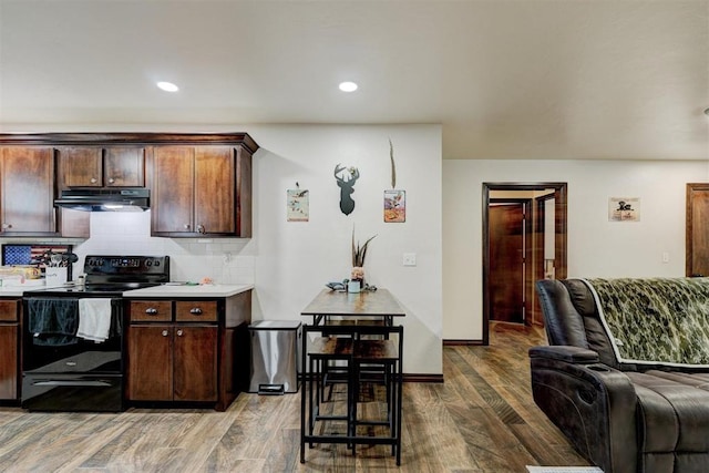 kitchen with black / electric stove, decorative backsplash, dark brown cabinets, and hardwood / wood-style floors