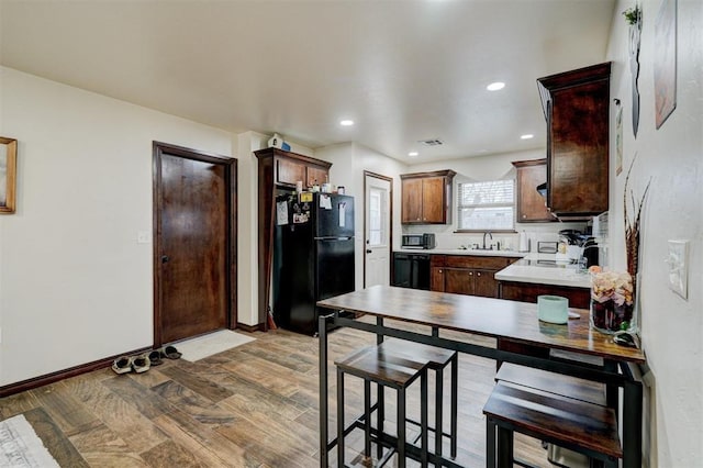 kitchen with kitchen peninsula, sink, and black appliances