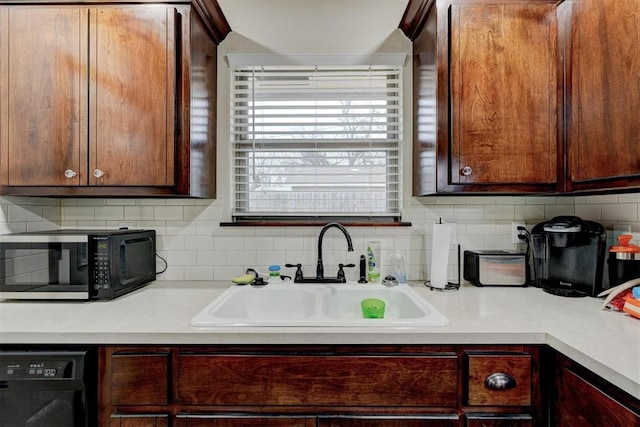 kitchen featuring sink, backsplash, and black appliances