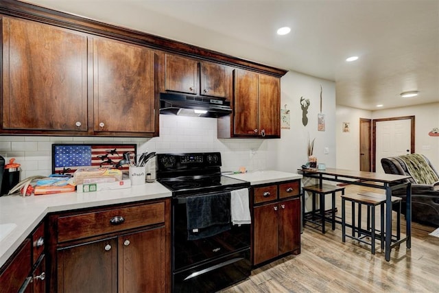 kitchen with decorative backsplash, electric range, dark brown cabinetry, and light hardwood / wood-style floors