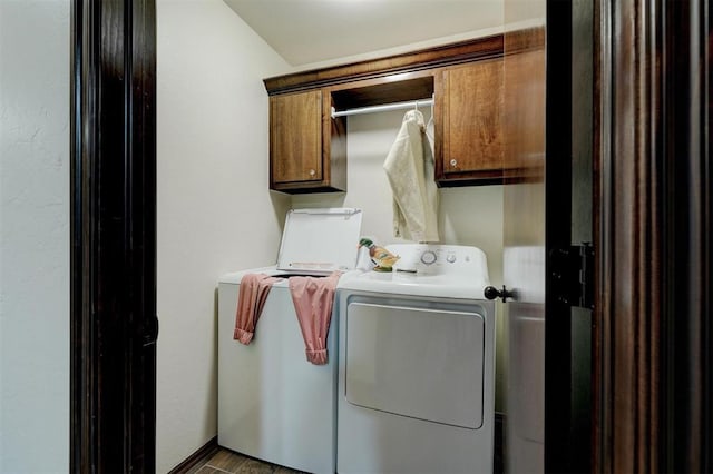 clothes washing area with cabinets, hardwood / wood-style flooring, and washer and clothes dryer