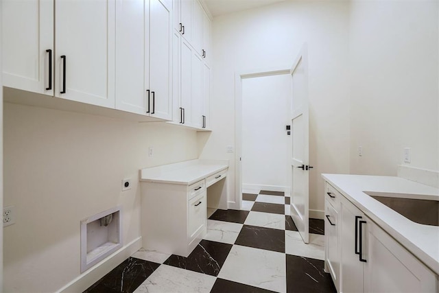 clothes washing area with cabinets, hookup for an electric dryer, and sink