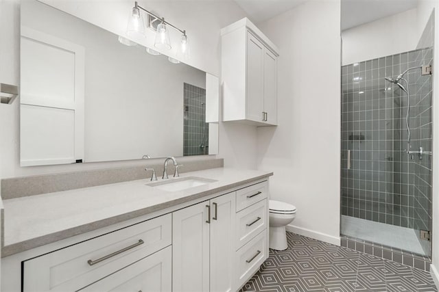 bathroom with vanity, tile patterned floors, toilet, and tiled shower