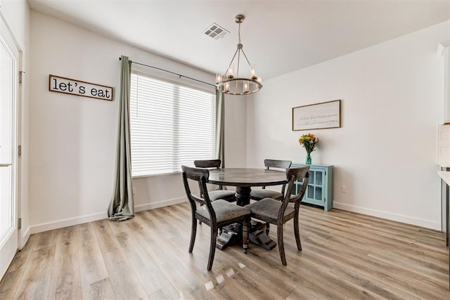 dining room with an inviting chandelier and light hardwood / wood-style flooring