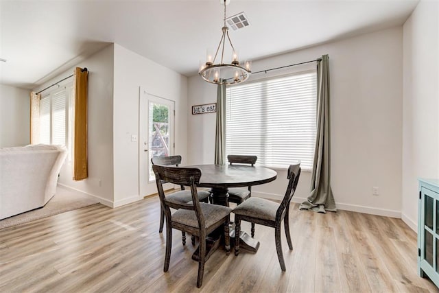 dining space with a notable chandelier and light hardwood / wood-style flooring