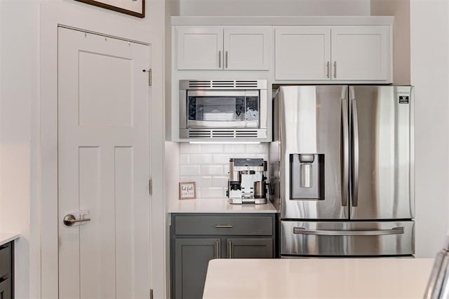 kitchen with white cabinetry, appliances with stainless steel finishes, gray cabinets, and backsplash