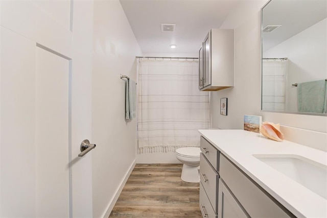 bathroom with wood-type flooring, toilet, and vanity