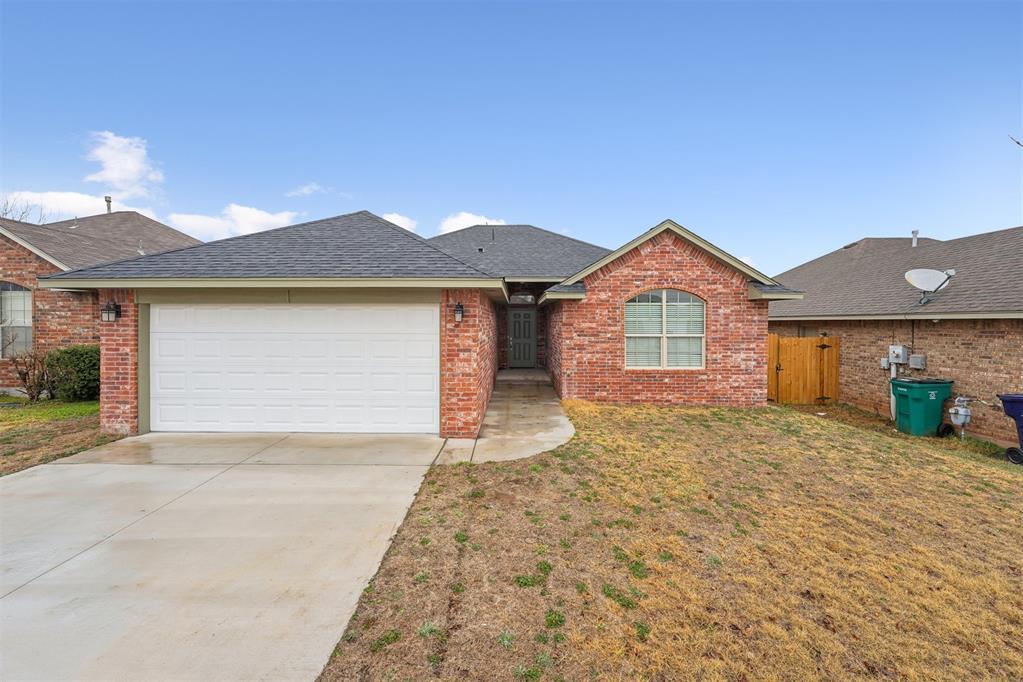 ranch-style home featuring a garage and a front yard