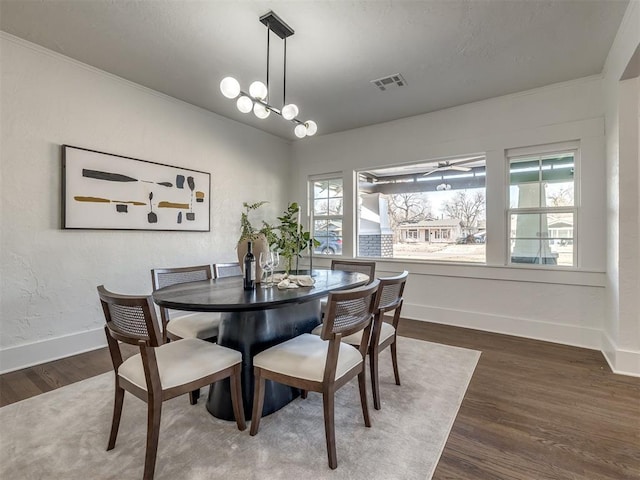 dining area with dark wood-style floors, a chandelier, visible vents, and baseboards