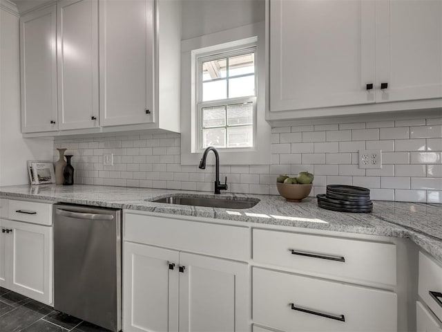 kitchen featuring a sink, white cabinetry, stainless steel dishwasher, light stone countertops, and tasteful backsplash