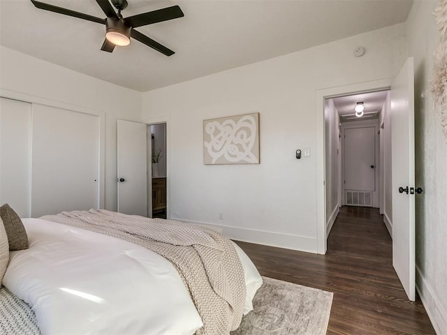 bedroom featuring ceiling fan, visible vents, baseboards, a closet, and dark wood-style floors