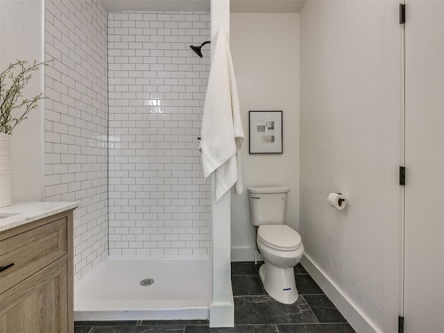 full bath featuring a stall shower, vanity, toilet, and baseboards