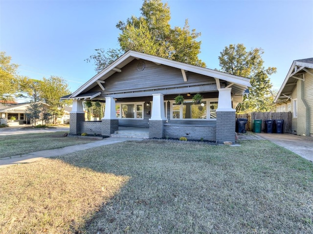 view of front of property with brick siding, a front yard, and fence