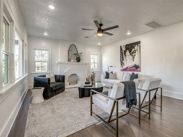 living area featuring visible vents, dark wood finished floors, and a textured ceiling