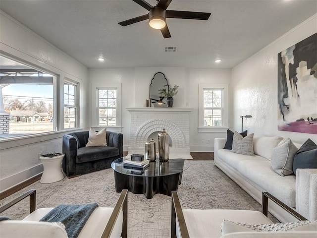 living room featuring recessed lighting, visible vents, a brick fireplace, wood finished floors, and baseboards