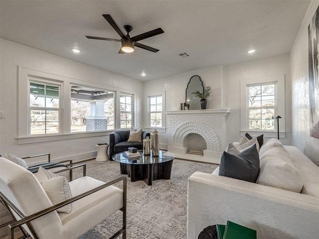 living room with a wealth of natural light, visible vents, ceiling fan, and recessed lighting