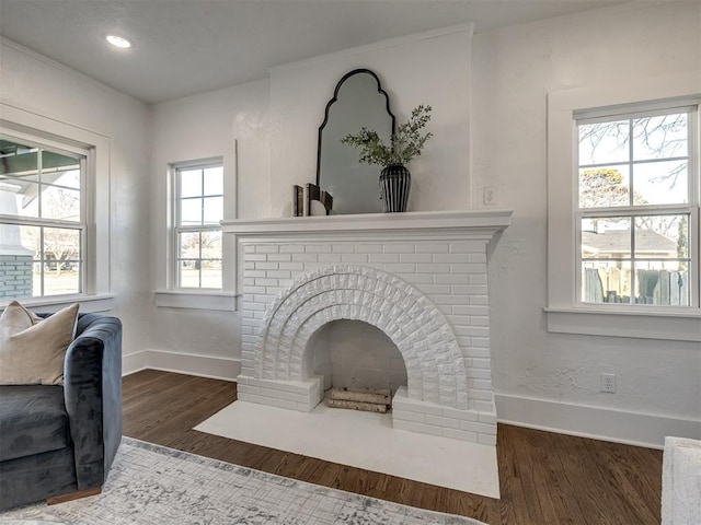 room details featuring recessed lighting, a brick fireplace, baseboards, and wood finished floors