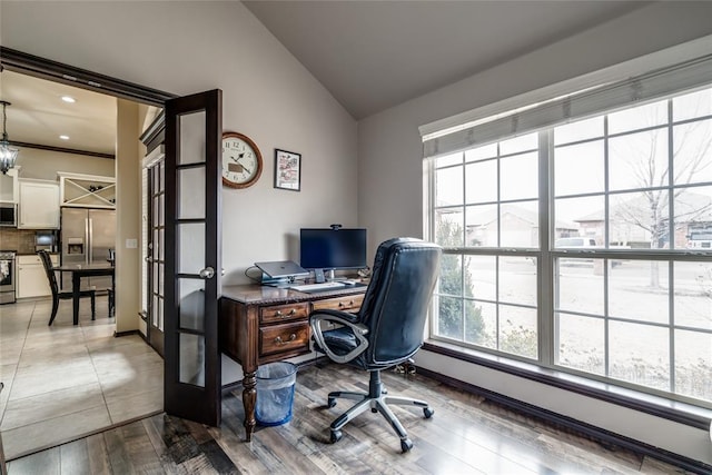 office with french doors, a baseboard radiator, lofted ceiling, and light wood-type flooring