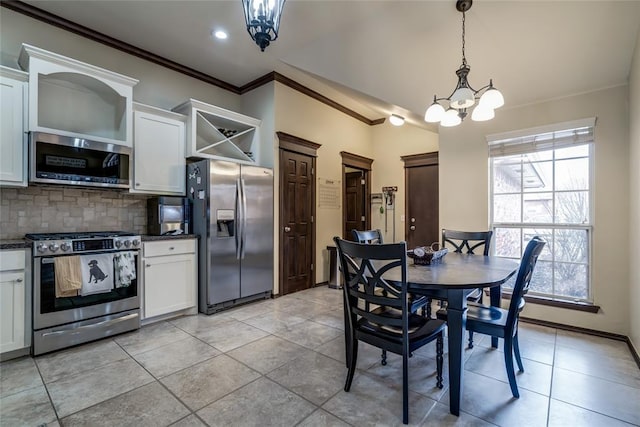 dining room featuring ornamental molding, light tile patterned floors, and an inviting chandelier