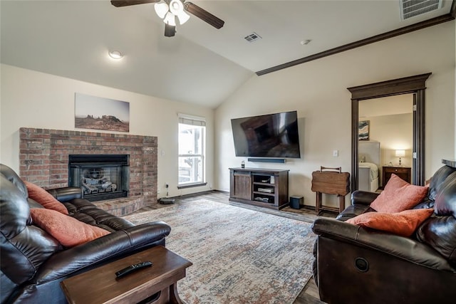 living room with a fireplace, vaulted ceiling, wood-type flooring, and ceiling fan