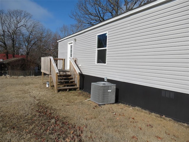 view of side of property featuring cooling unit and a lawn