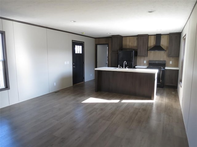 kitchen with black appliances, a kitchen island with sink, dark hardwood / wood-style flooring, and wall chimney exhaust hood