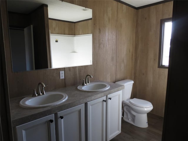 bathroom featuring hardwood / wood-style flooring, vanity, wooden walls, and toilet