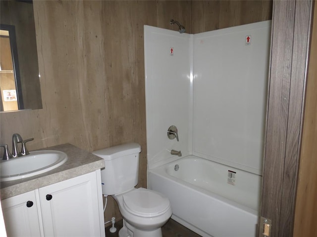 full bathroom with wooden walls, shower / tub combination, vanity, and toilet