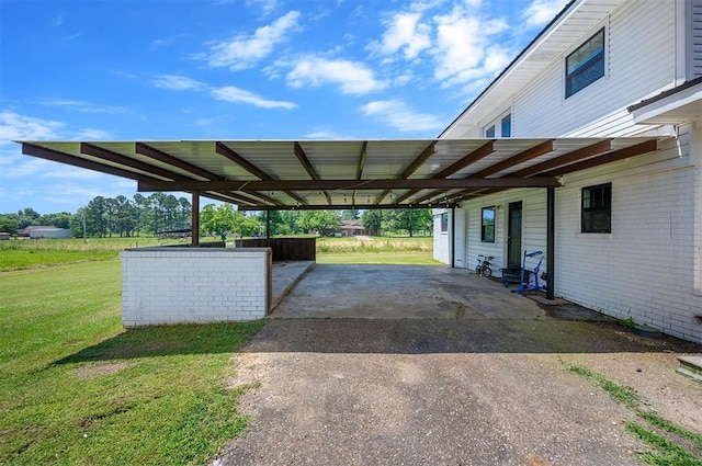 view of vehicle parking featuring a lawn and a carport