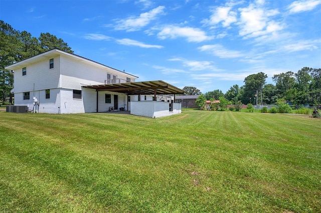 rear view of property with central AC and a yard