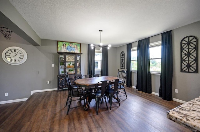 dining area featuring dark wood-type flooring, a chandelier, and a textured ceiling