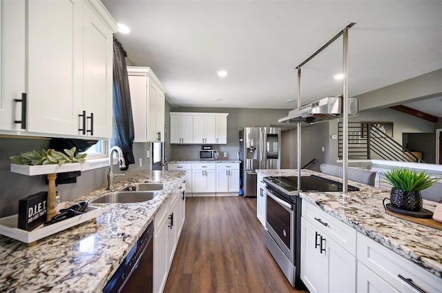 kitchen featuring appliances with stainless steel finishes, white cabinetry, sink, dark hardwood / wood-style flooring, and light stone countertops