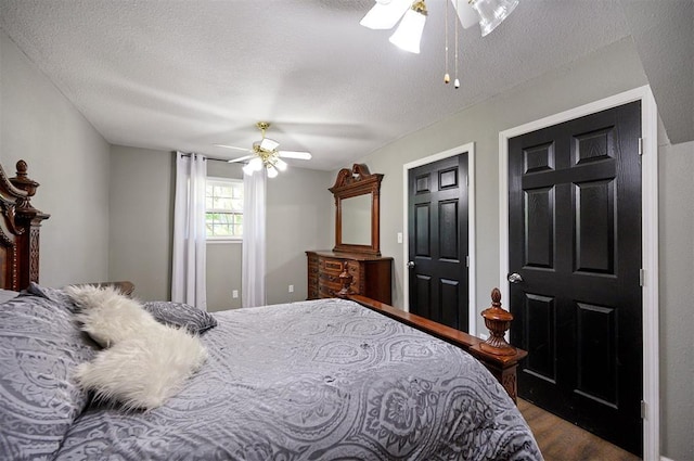 bedroom featuring ceiling fan, dark hardwood / wood-style floors, and a textured ceiling