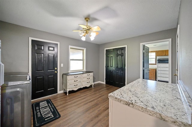 foyer featuring a healthy amount of sunlight, dark hardwood / wood-style floors, washing machine and dryer, and a textured ceiling