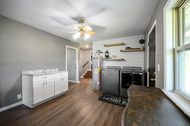 kitchen with water heater, washing machine and dryer, light stone counters, white cabinets, and dark hardwood / wood-style flooring