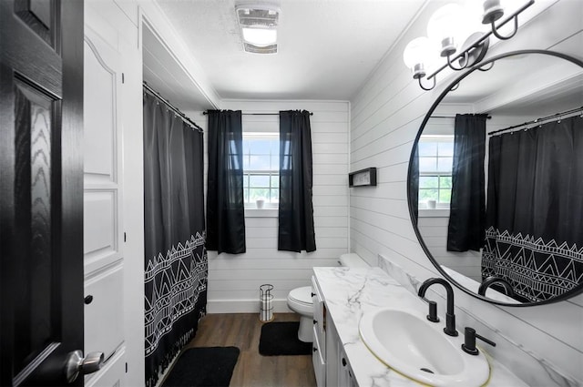 bathroom with toilet, wood walls, a shower with curtain, wood-type flooring, and vanity