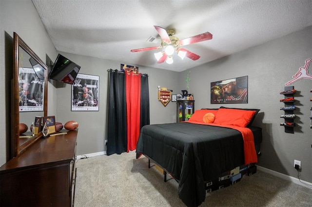 bedroom with ceiling fan, carpet floors, and a textured ceiling