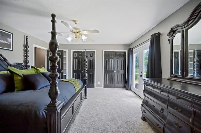 carpeted bedroom featuring access to exterior, two closets, and ceiling fan