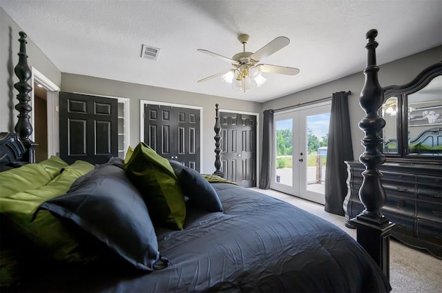 carpeted bedroom with two closets, access to outside, ceiling fan, a textured ceiling, and french doors