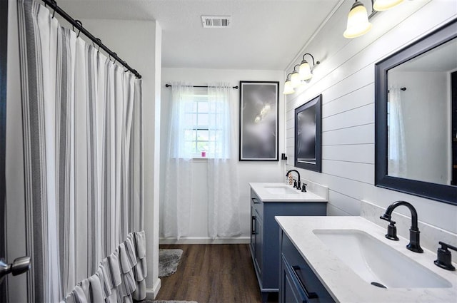 bathroom with a shower with shower curtain, vanity, hardwood / wood-style floors, and a textured ceiling