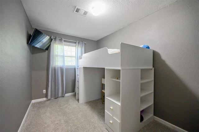 bedroom featuring carpet flooring and a textured ceiling