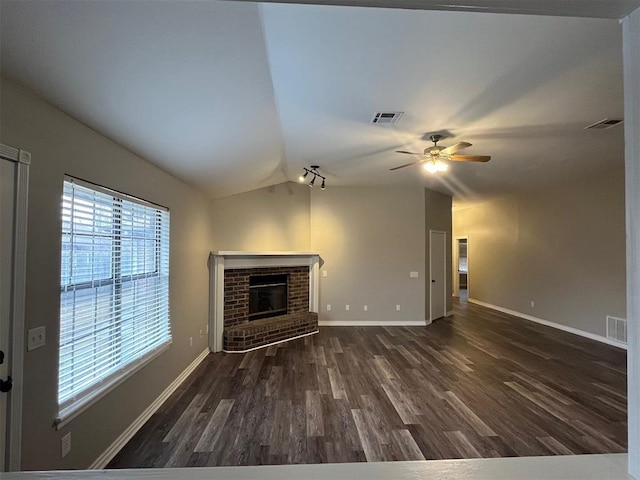 unfurnished living room with vaulted ceiling, dark hardwood / wood-style floors, ceiling fan, and a fireplace