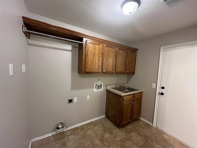 washroom featuring electric dryer hookup, sink, hookup for a washing machine, and cabinets