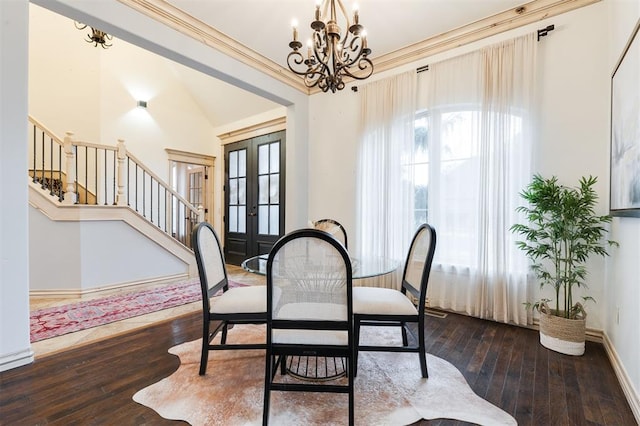 dining space with a chandelier, wood-type flooring, french doors, and a healthy amount of sunlight