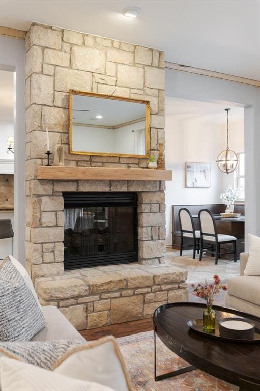 living room featuring crown molding and a stone fireplace