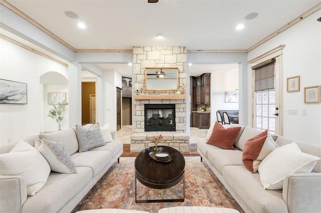 living room with crown molding and a fireplace