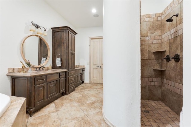 bathroom featuring a tile shower and vanity