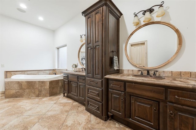 bathroom with vanity and tiled bath