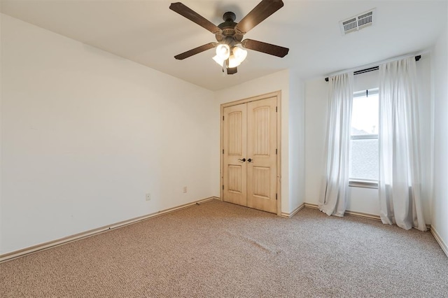 unfurnished bedroom featuring light colored carpet, a closet, and ceiling fan